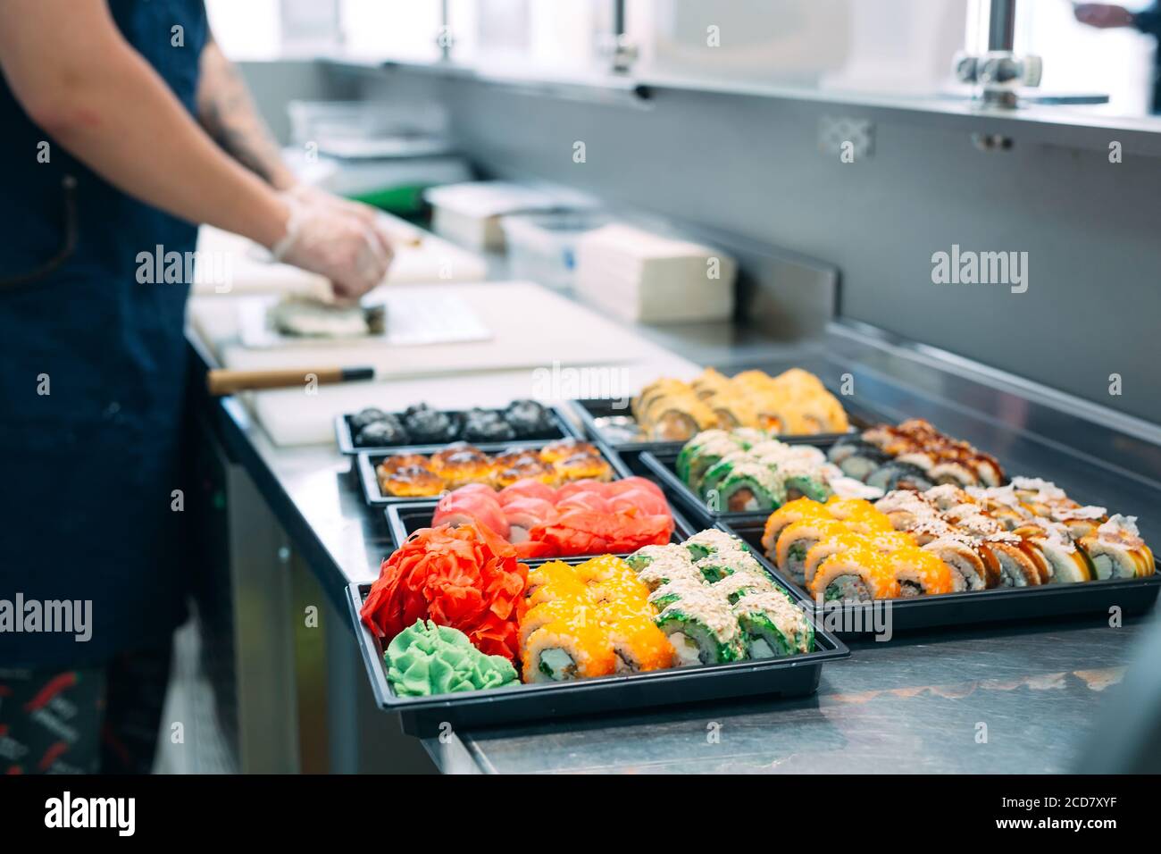 Sushi-Lieferung. Viele Sorten Sushi in einer Plastikbox sind für die Lieferung vorbereitet. Stockfoto