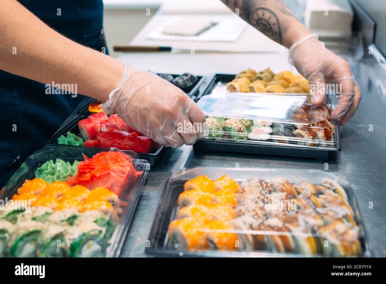 Sushi-Lieferung. Viele Sorten Sushi in einer Plastikbox sind für die Lieferung vorbereitet. Stockfoto