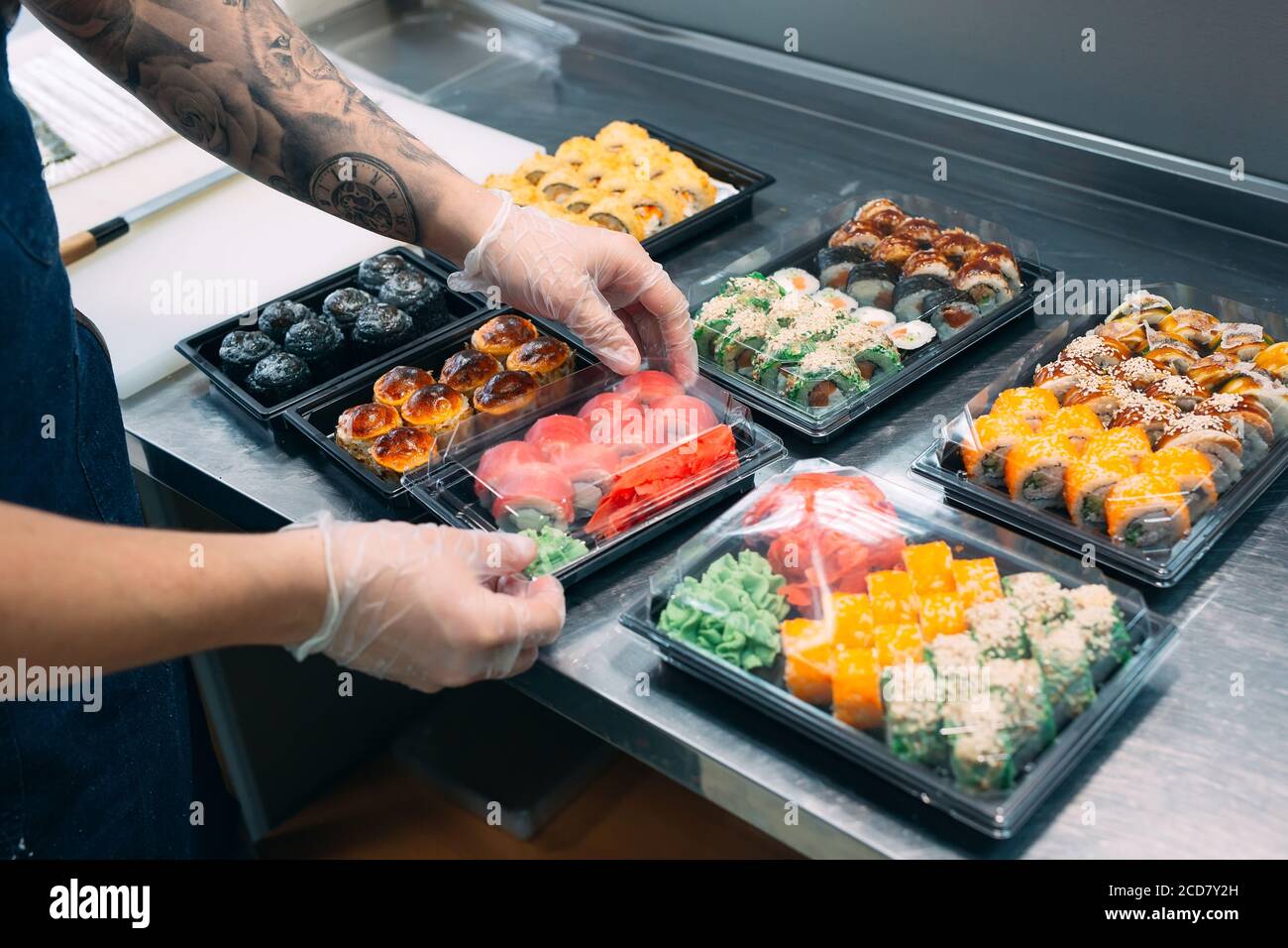 Sushi-Lieferung. Viele Sorten Sushi in einer Plastikbox sind für die Lieferung vorbereitet. Stockfoto