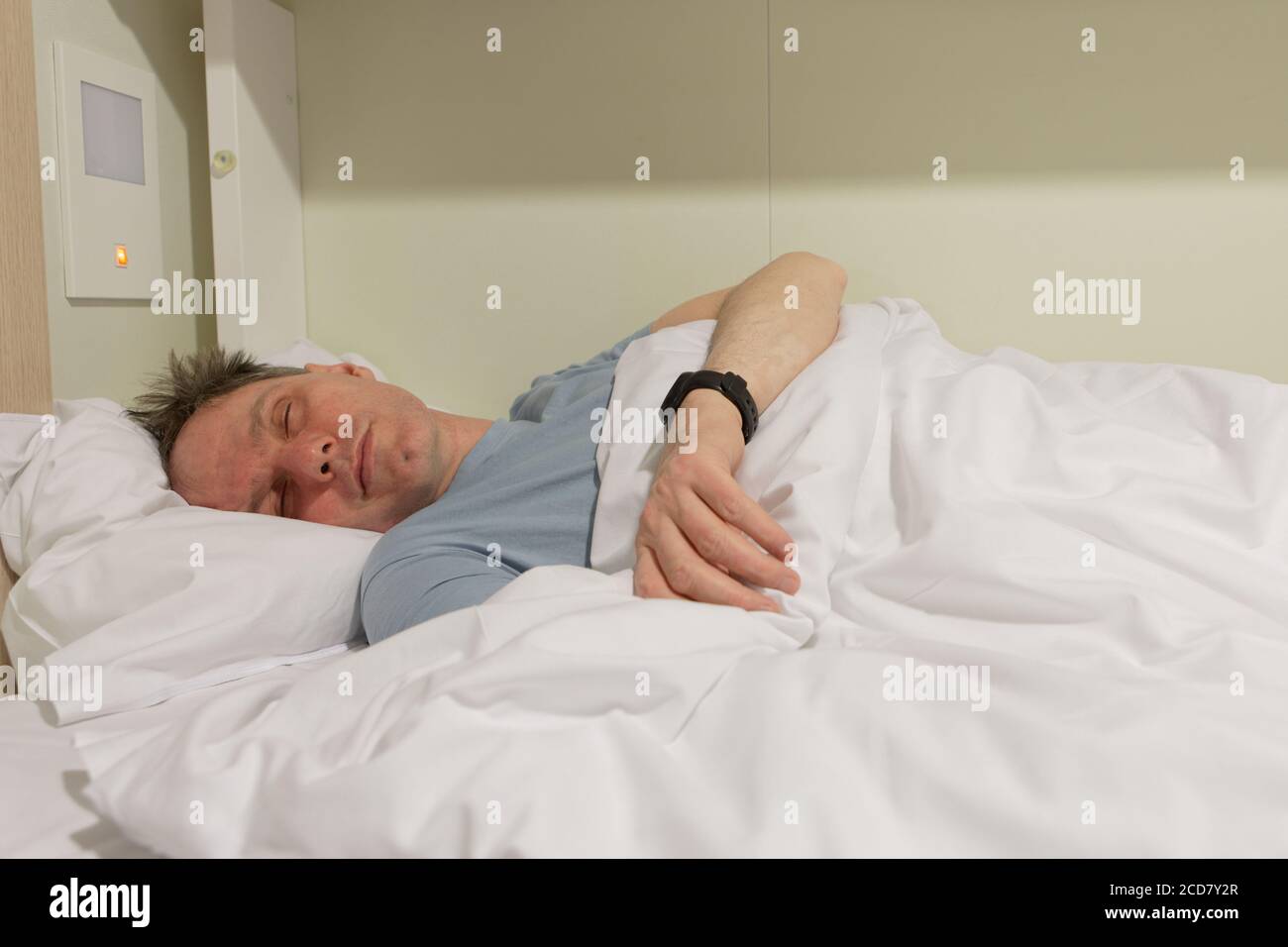 Mann, der auf einem Liegeplatz in einer Kabine einer Kreuzfahrt schläft Versand Stockfoto