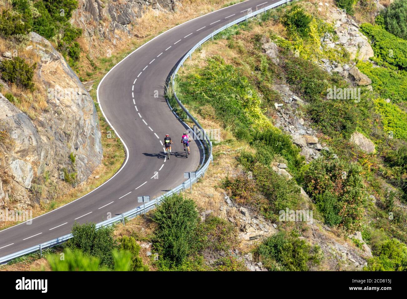 Blick auf zwei Radfahrer auf einer kurvigen Bergstraße, Sant Pere de Rodes, Costa Brava, Girona, Katalonien, Spanien Stockfoto