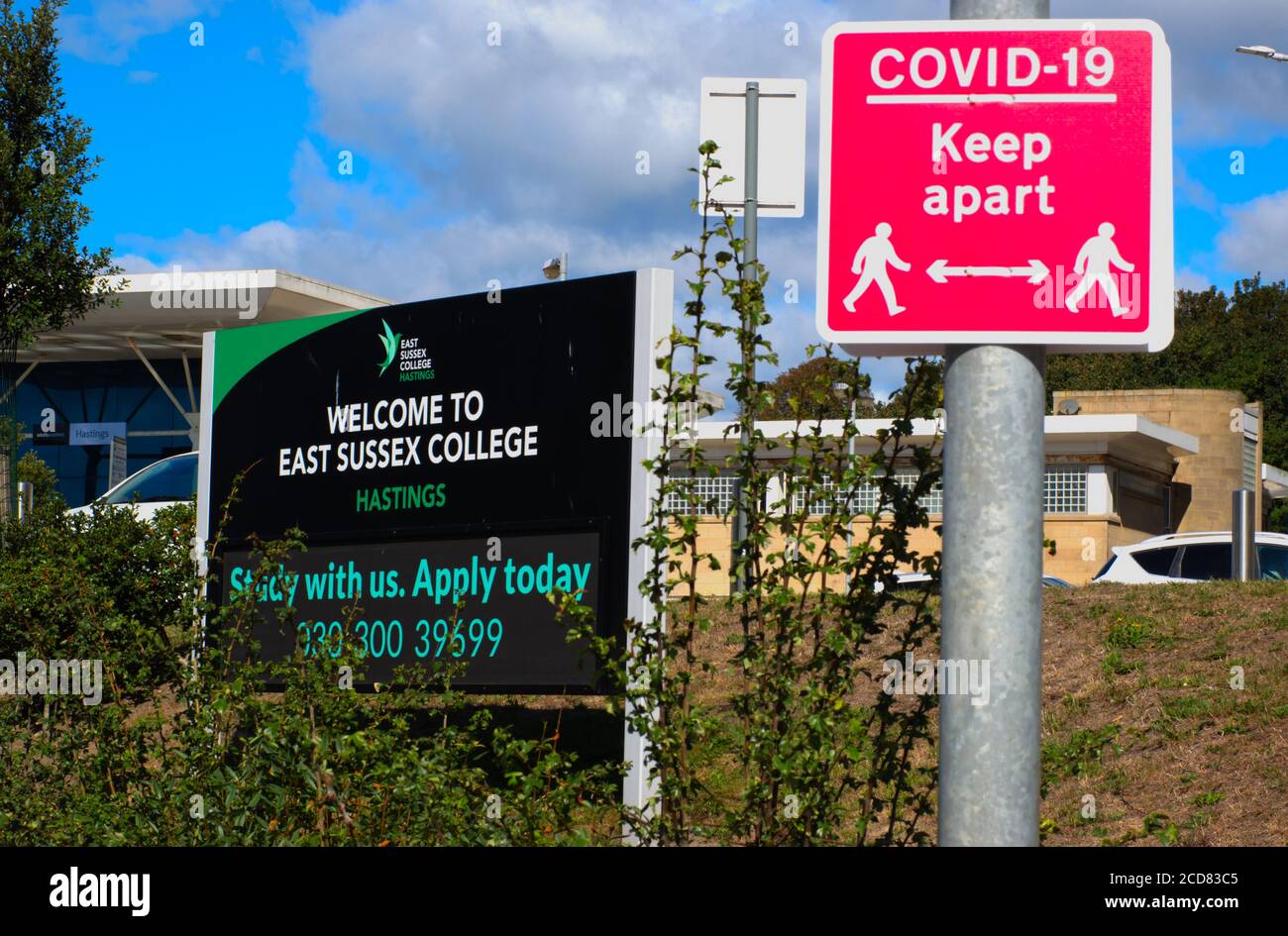 Ein Schild für East Sussex College, Hastings Campus, neben einem 'Covid 19 halten auseinander Zeichen' in Hastings, Sussex, England, Großbritannien. Stockfoto
