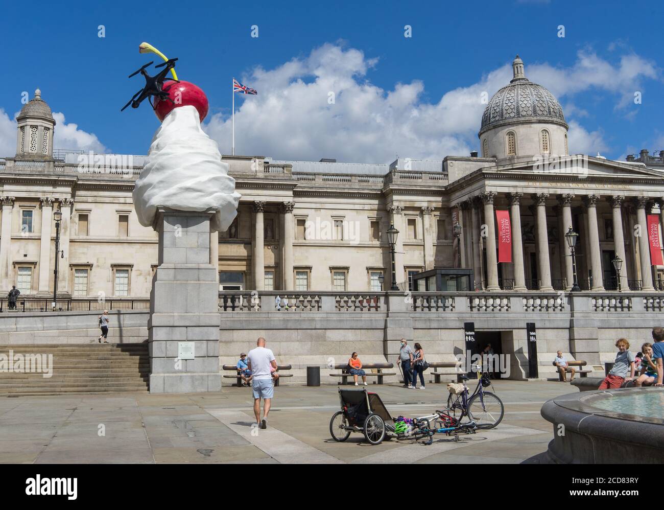 Die Endskulptur auf dem vierten Sockel am Trafalgar Square. Schlagsahne, eine Fliege und eine Drohne auf einer Kirsche. Weitwinkelansicht. London Stockfoto