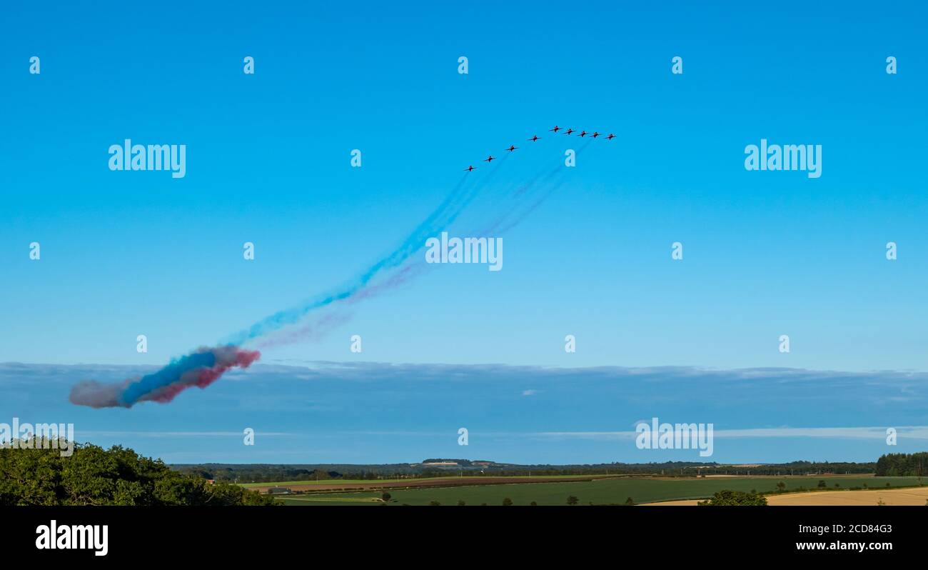 Das Royal Air Force RAF Aeronautics Display Team oder Red Arrows fliegen an einem sonnigen Sommertag über East Lothian mit klarem blauen Himmel, Schottland, Großbritannien Stockfoto