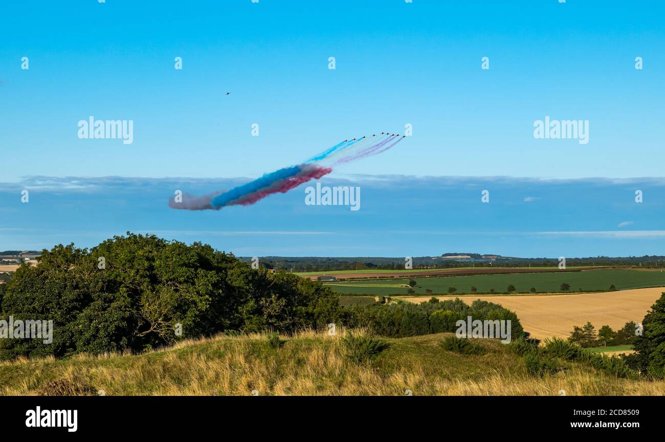 Das Royal Air Force RAF Aeronautics Display Team oder Red Arrows fliegen an einem sonnigen Sommertag über East Lothian mit klarem blauen Himmel, Schottland, Großbritannien Stockfoto