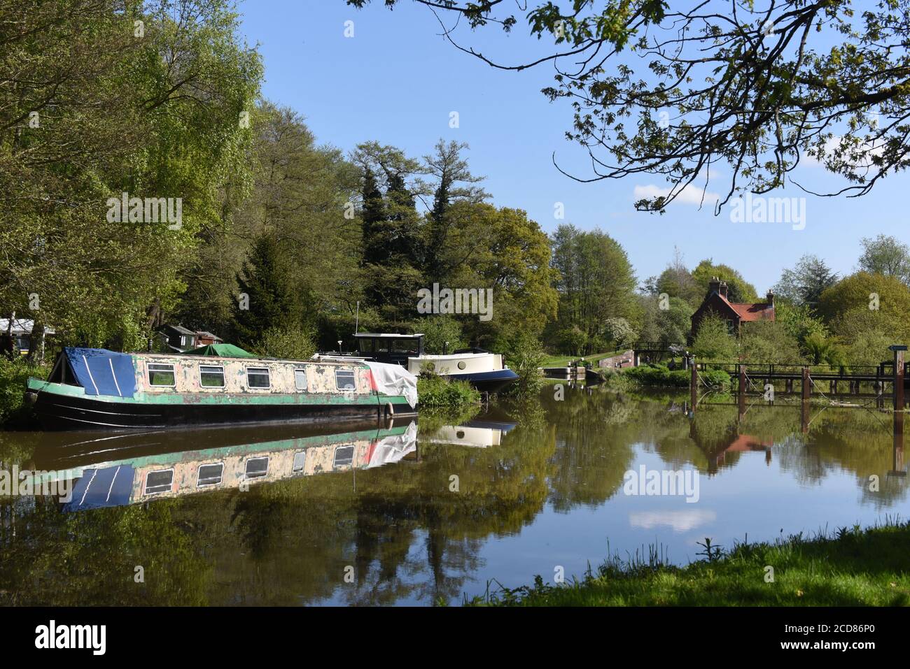 Boote spiegeln sich in stillem Wasser auf der schönen Wey Navigation In Surrey Stockfoto