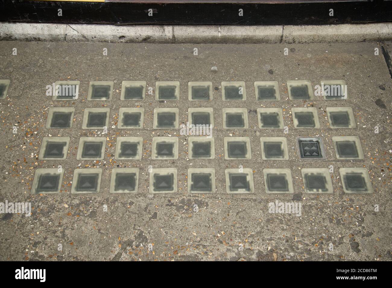 Pavement Linsen in Beton in einem Rechteck gesetzt. Wird verwendet, um Tageslicht in einen Keller zu lassen. Geeignet als Hintergrund. Stockfoto