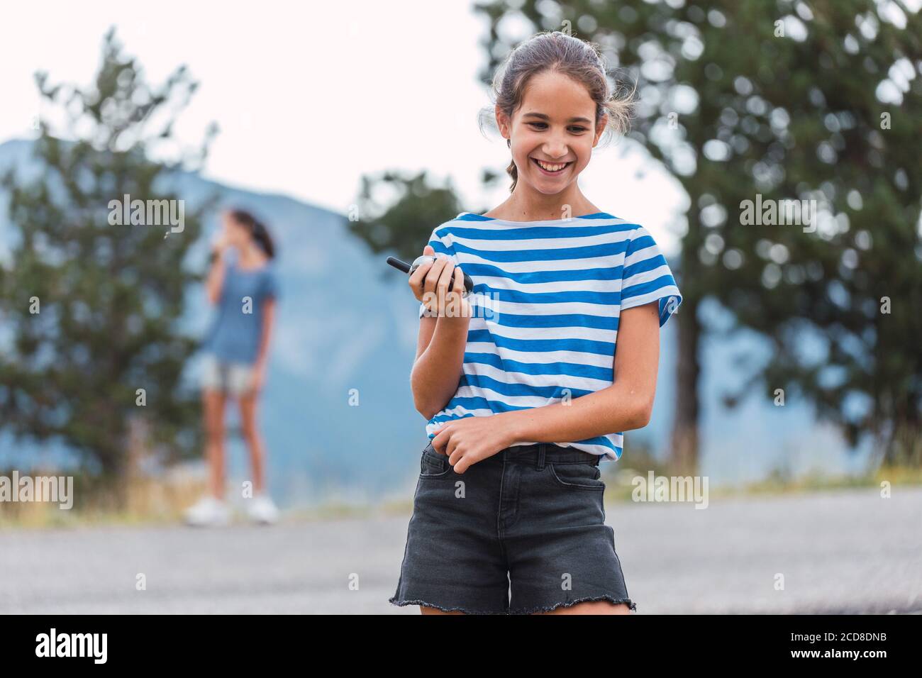 Zwei Mädchen kommunizieren über Walkie-Talkies während einer Wanderung durch die Hölzer Stockfoto