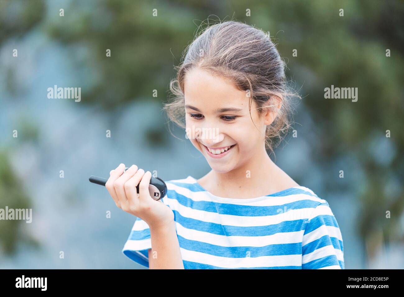 Nahaufnahme eines lächelnden Mädchens mit einem Walkie-Talkie im Freien Stockfoto