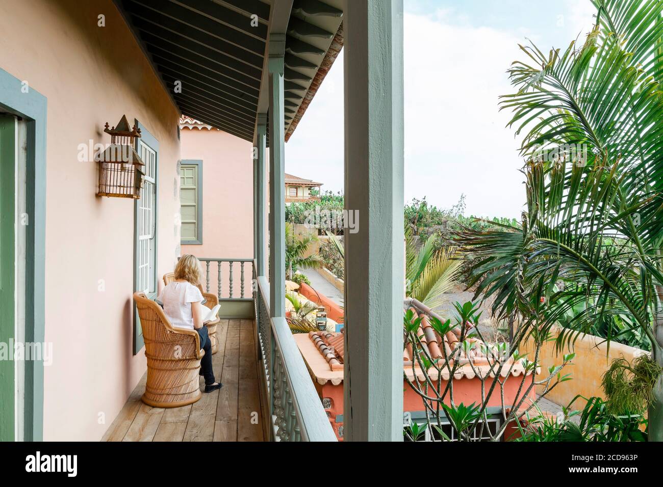 Spanien, Kanarische Inseln, La Palma, junge Frau allein unter der Veranda eines Luxushotels im Kolonialstil Stockfoto