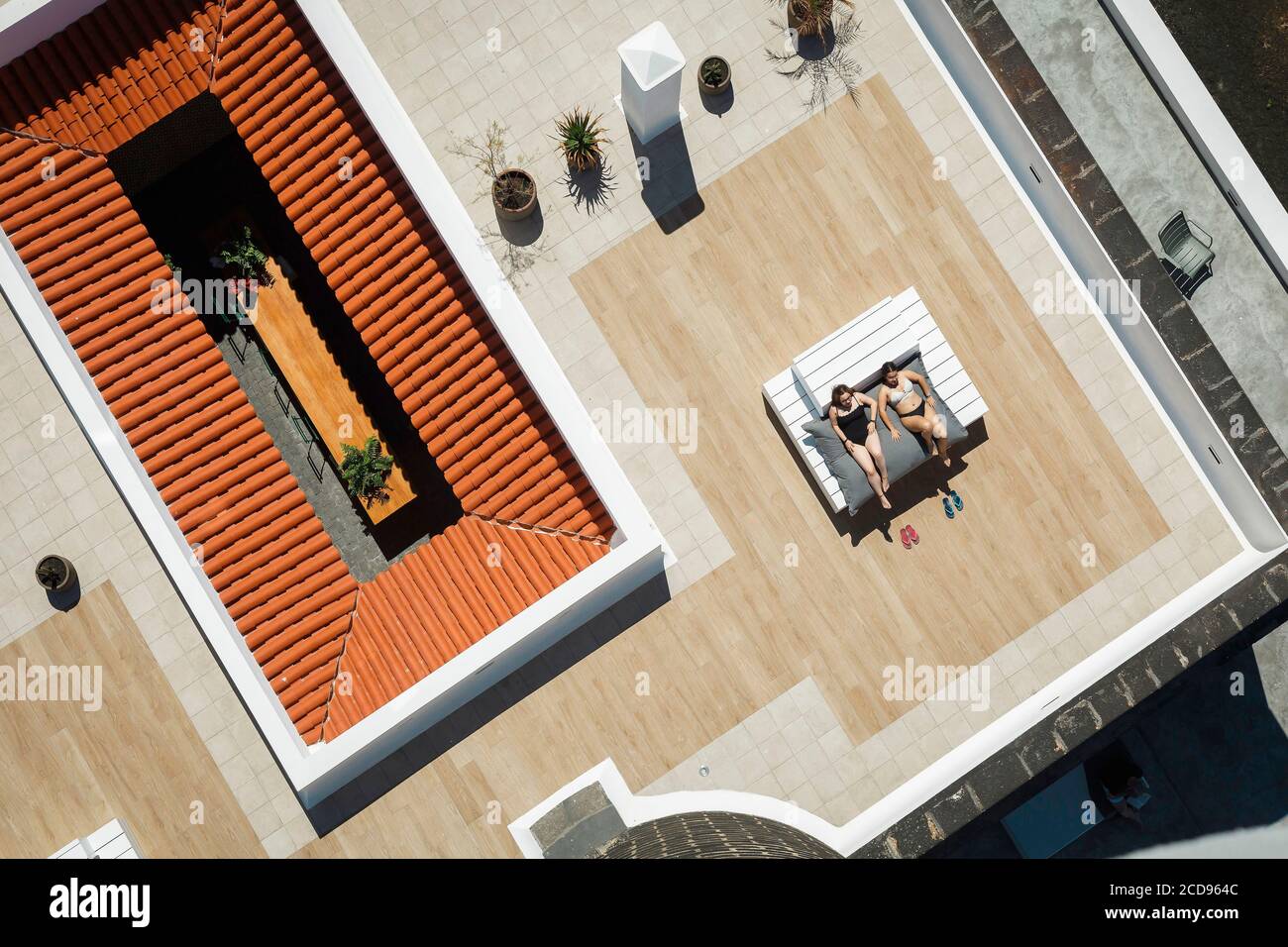 Spanien, Kanarische Inseln, La Palma, Touristen, die am Rande eines Schwimmbades am Meer ruhen (Luftaufnahme) Stockfoto