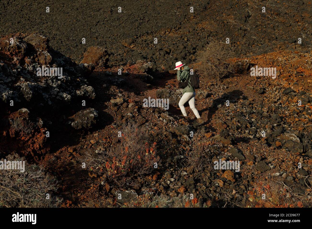 Spanien, Kanarische Inseln, La Palma, Wanderer auf einem Weg in einer Wüste und vulkanischen Umgebung bei Sonnenaufgang Stockfoto