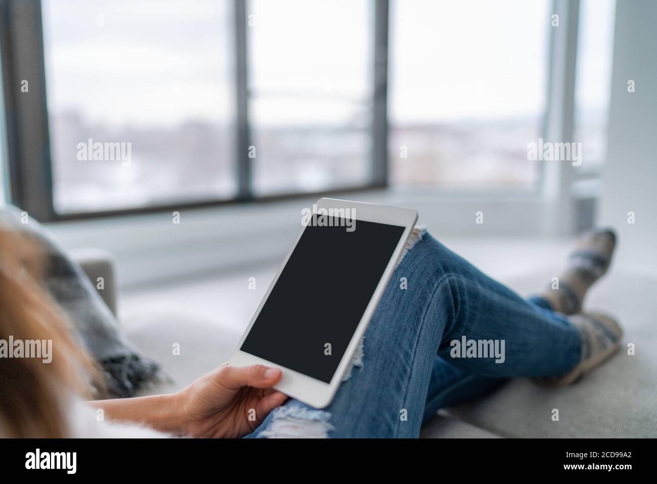 Tablet-Frau mit pc-Technologie-Gerät zu Hause entspannen auf Sofa sitzen Video schwarzen Bildschirm oder E-Book lesen. Moderner Lifestyle Stockfoto