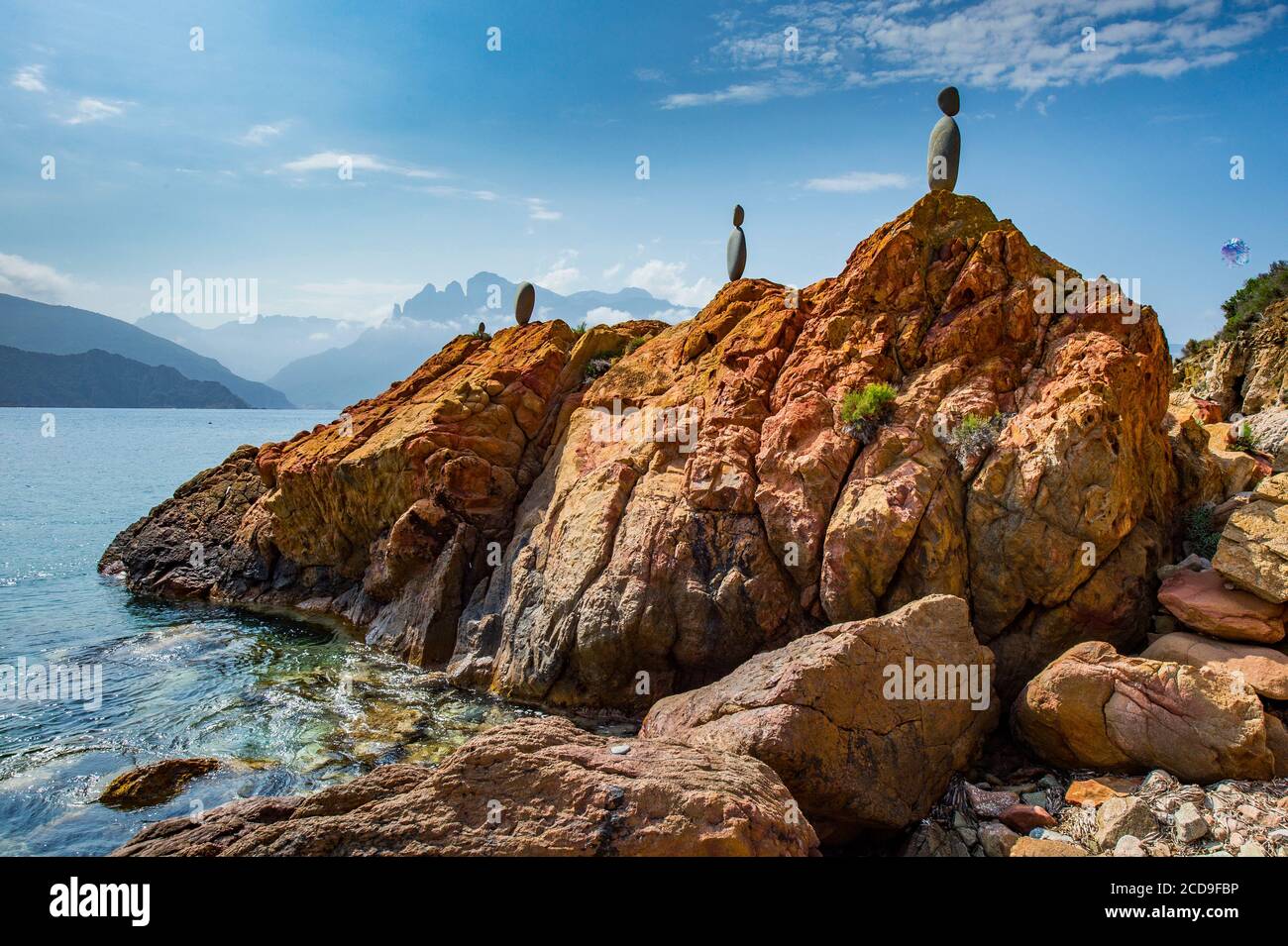 Frankreich, Corse du Sud, Porto, Golf von Porto am Strand von Gradelle hat ein Künstler große graue Kieselsteine gestapelt, um ephemere Statuen zu bilden, die auf den ockerfarbenen Felsen hervorstechen, ein Wunder Stockfoto