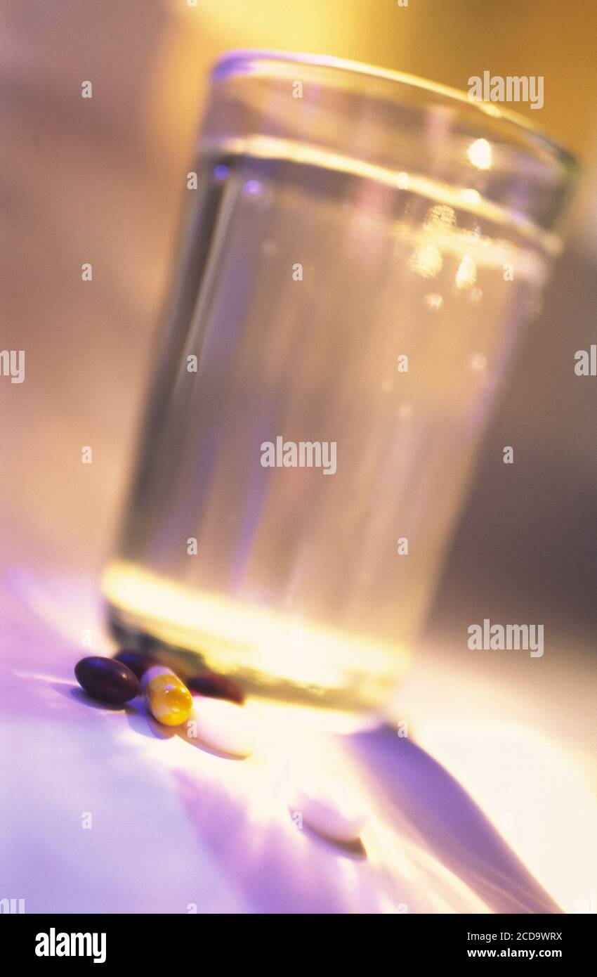 Glas sauberes Trinkwasser und Medikamente in Tabletten und Kapseln im  Sonnenlicht liegen auf dem Tisch Stockfotografie - Alamy