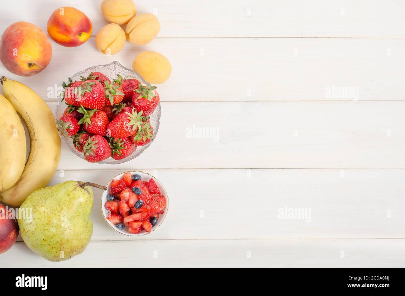 Frische Erdbeeren mit Früchten auf weißem Hintergrund mit Kopierplatz. Zutaten für Obstsalat. Stockfoto