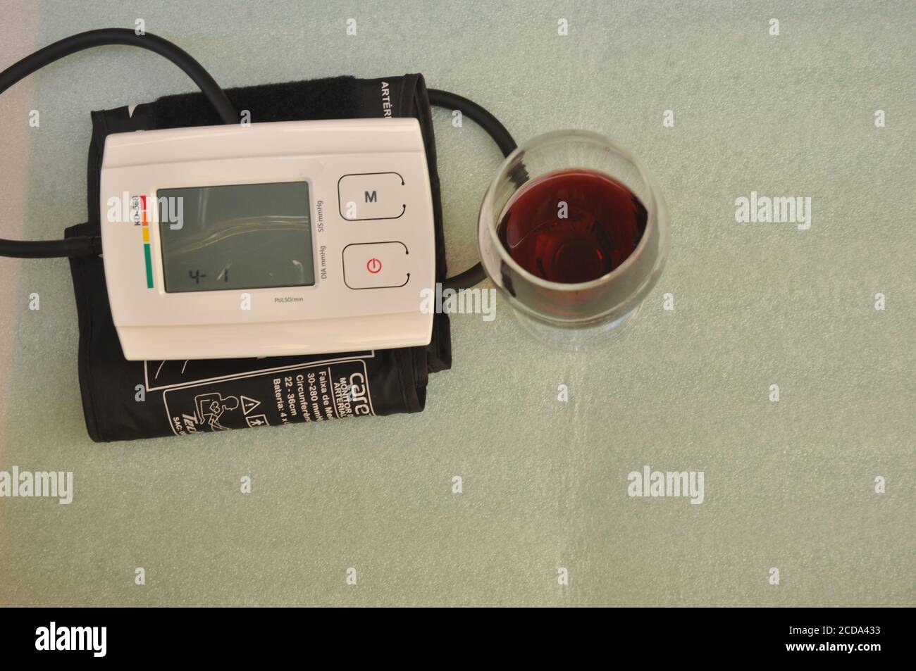 Digitales Druckgerät, mit Schlauch und Nylon-Armband zum Messen am Arm, mit  Weinglas auf weißem Hintergrund, mit Kopierraum in konzeptuellem Phot  Stockfotografie - Alamy
