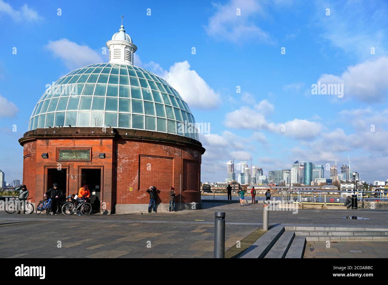 London, Vereinigtes Königreich - 02. Februar 2019: Gruppe von Radfahrern, die Greenwich Fuß Tunnel unter der Themse an sonnigen Tag, Fluss und Canary Wharf d Stockfoto