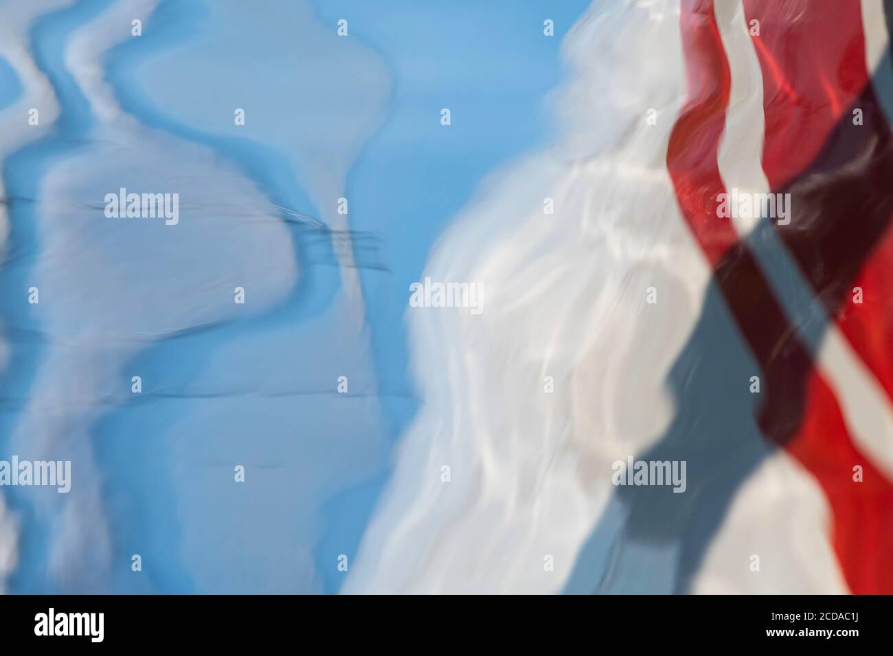 Spiegelung von Wolken und Segelboot im Wasser Stockfoto