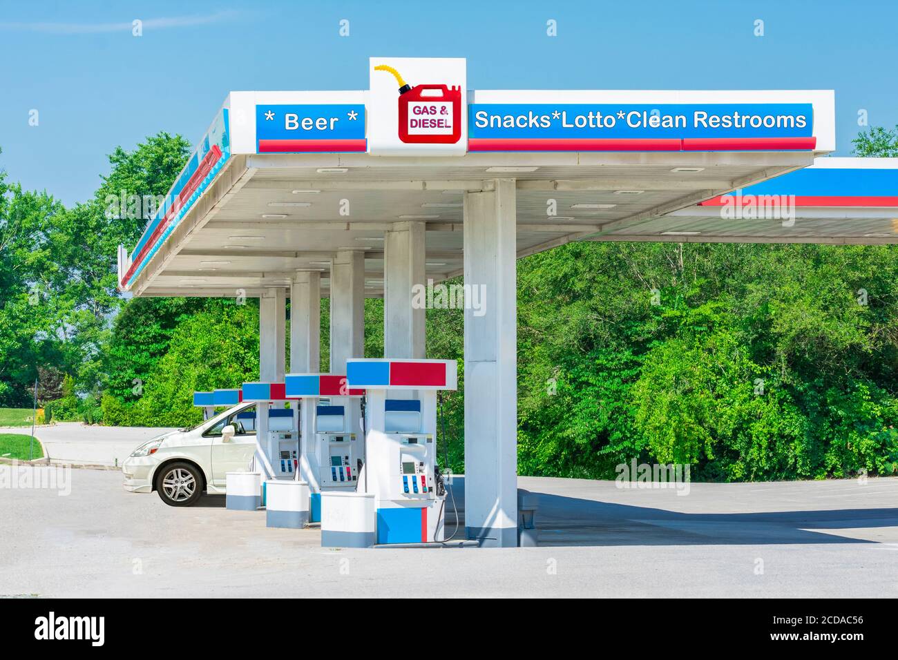 Horizontale Aufnahme eines nicht beschrifteten Lebensmittelladens an einer Tankstelle mit von Fotografen erstellten Schildern. Stockfoto