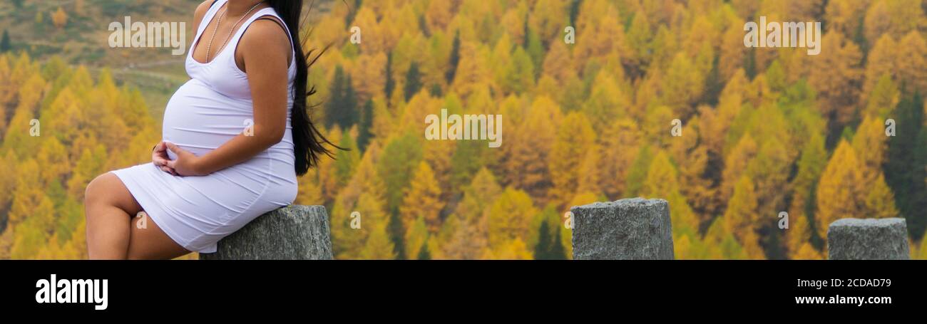 Schwangere Frau mit schönen Wald im Hintergrund Stockfoto