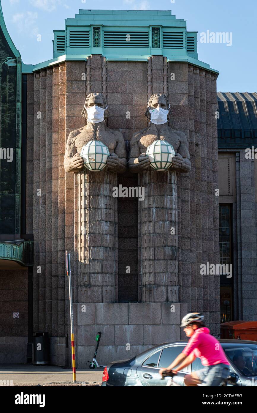 Statuen oder Skulpturen mit Gesichtsmasken am Haupteingang des Hauptbahnhofs in Helsinki, Finnland Stockfoto