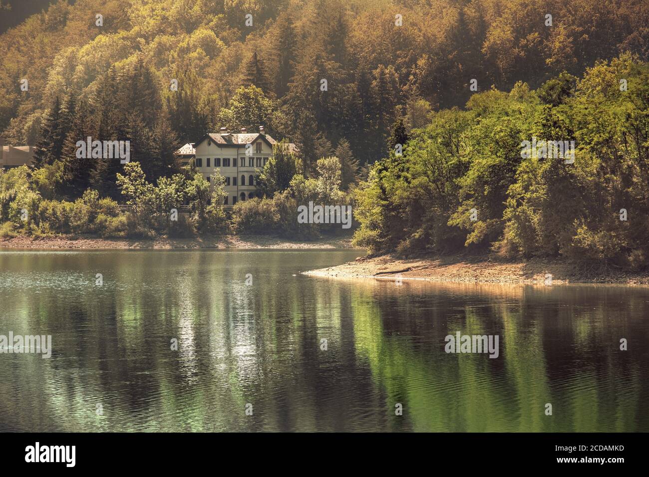Herbstliche See warme Töne Blick Gebäude mit Reflexionen auf dem Wasser Stockfoto