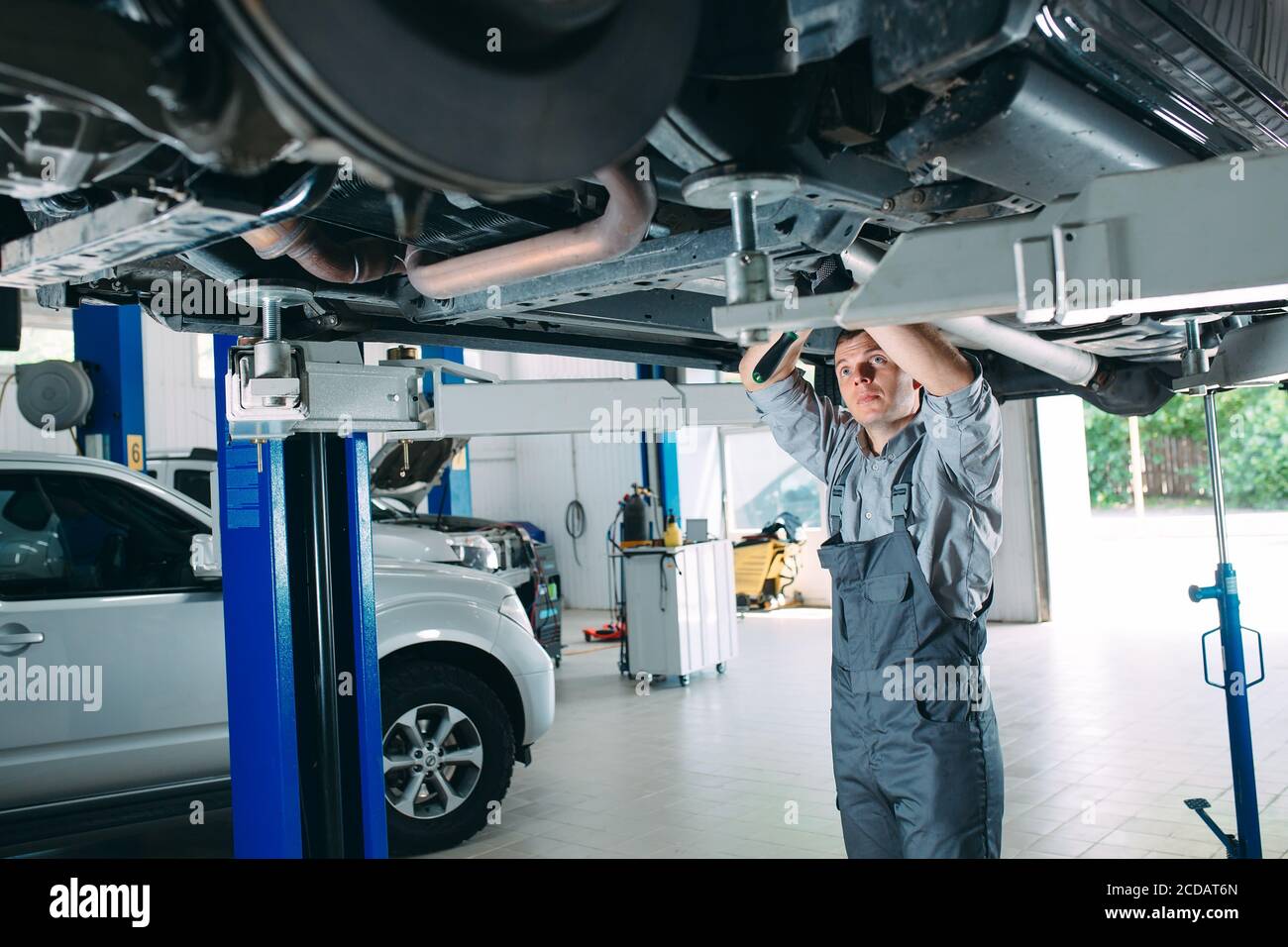 Porträt eines Mechanikers, der ein Fahrzeug repariert. Stockfoto