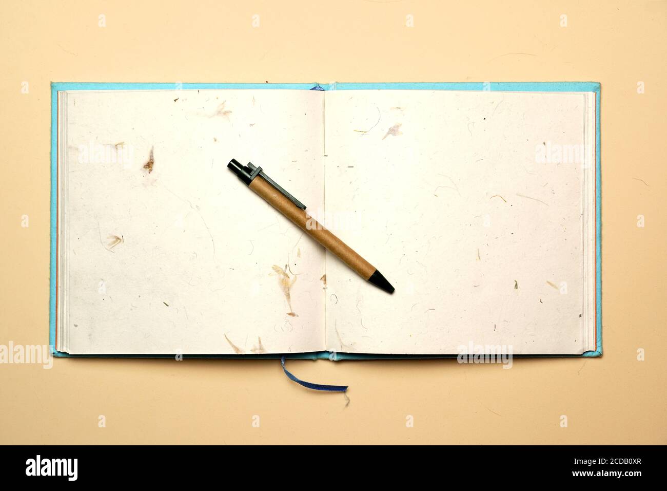 Arbeitsplatz mit Stift und Notizbuch auf gelbem Hintergrund. Flach liegend Stockfoto