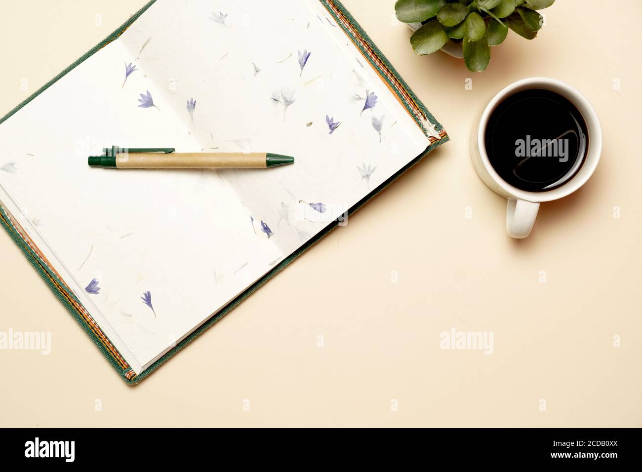 Arbeitsplatz mit Kaffeestift und Notizbuch auf gelbem Hintergrund. Flaches Design Stockfoto