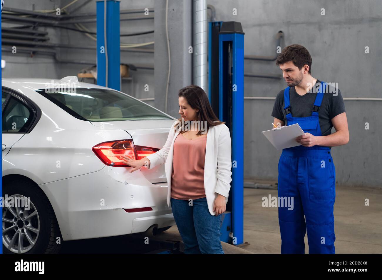 Der Mechaniker informiert den Kunden über die Reparatur eines Auto Stockfoto