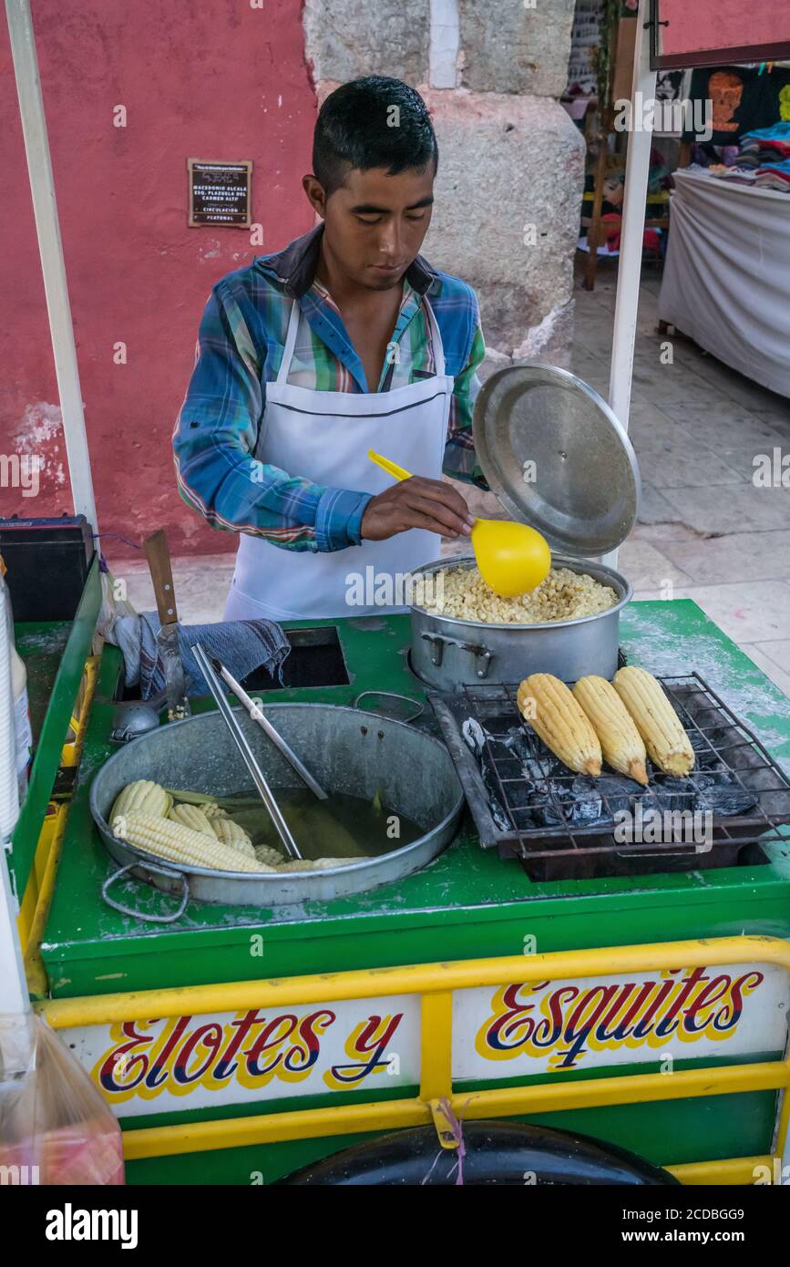 Ein Verkäufer, der Eloten und Ezitate auf der Straße im historischen Zentrum von Oaxaca, Mexiko verkauft. Elotes sind Mais auf dem Kob, die zuerst gekocht werden, dann Stockfoto