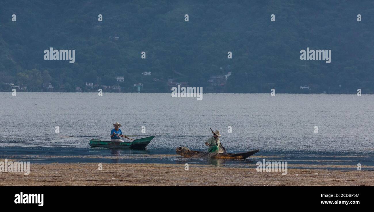 Zwei Maya-Fischer in cayucos fischen auf einem Moosbett am Atitlan-See, Guatemala. Stockfoto