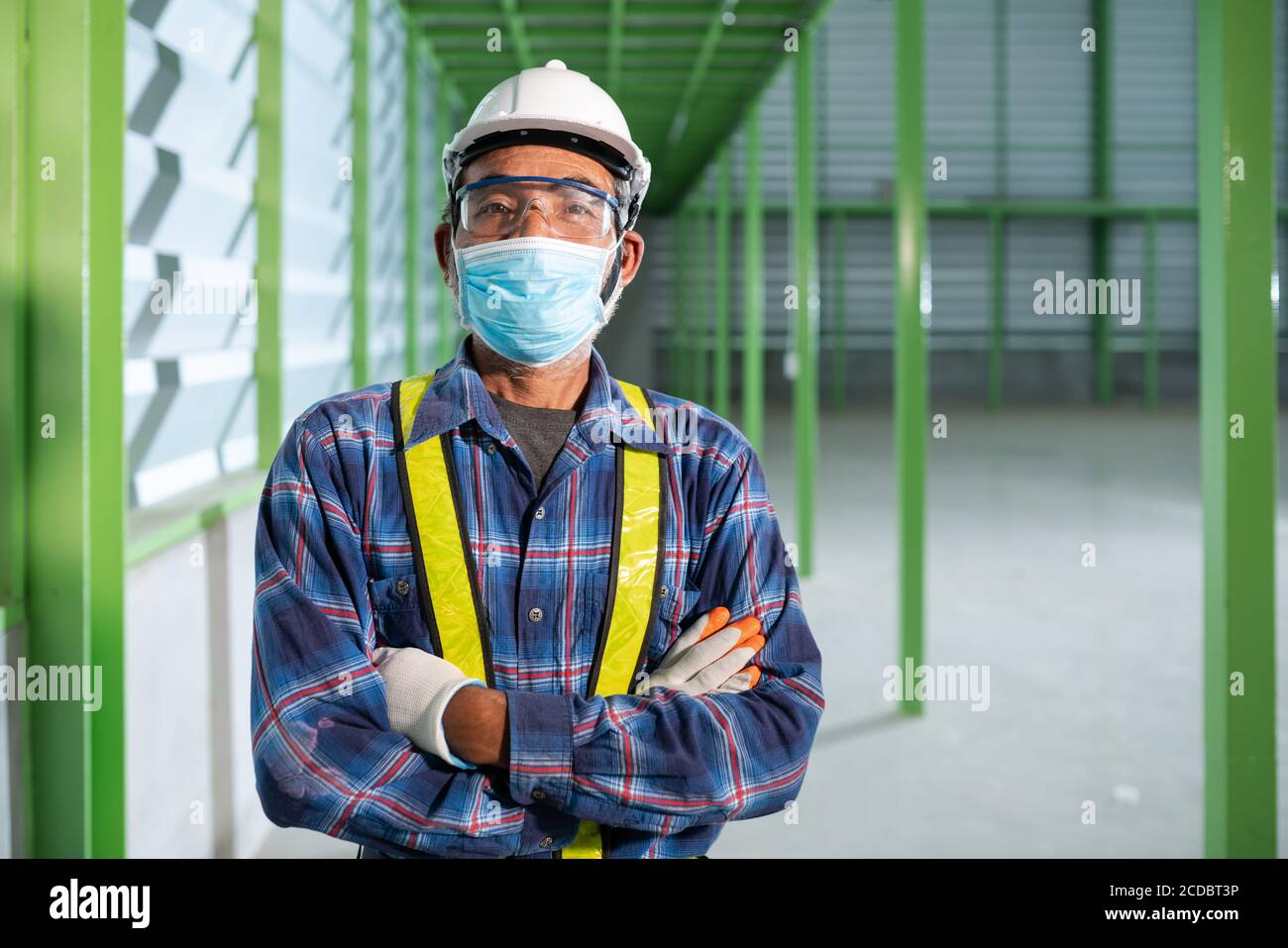 Leitender Ingenieur, der eine Maske trägt, um normal zu arbeiten Stockfoto