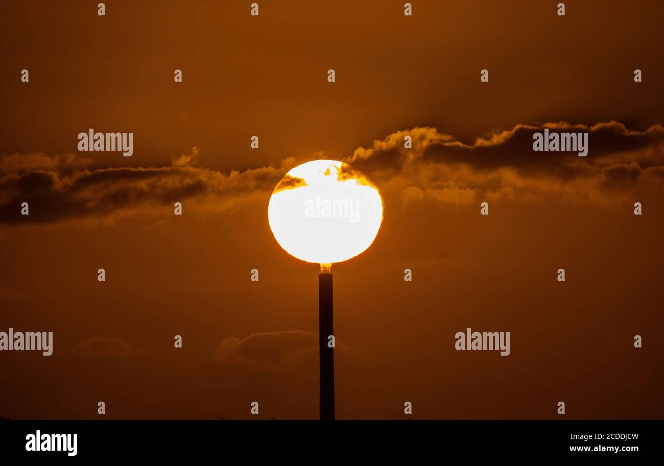 Solarstrom.die Sonnenuntergänge hinter dem Kamin eines Kraftwerks in Melbourne Australien. Stockfoto