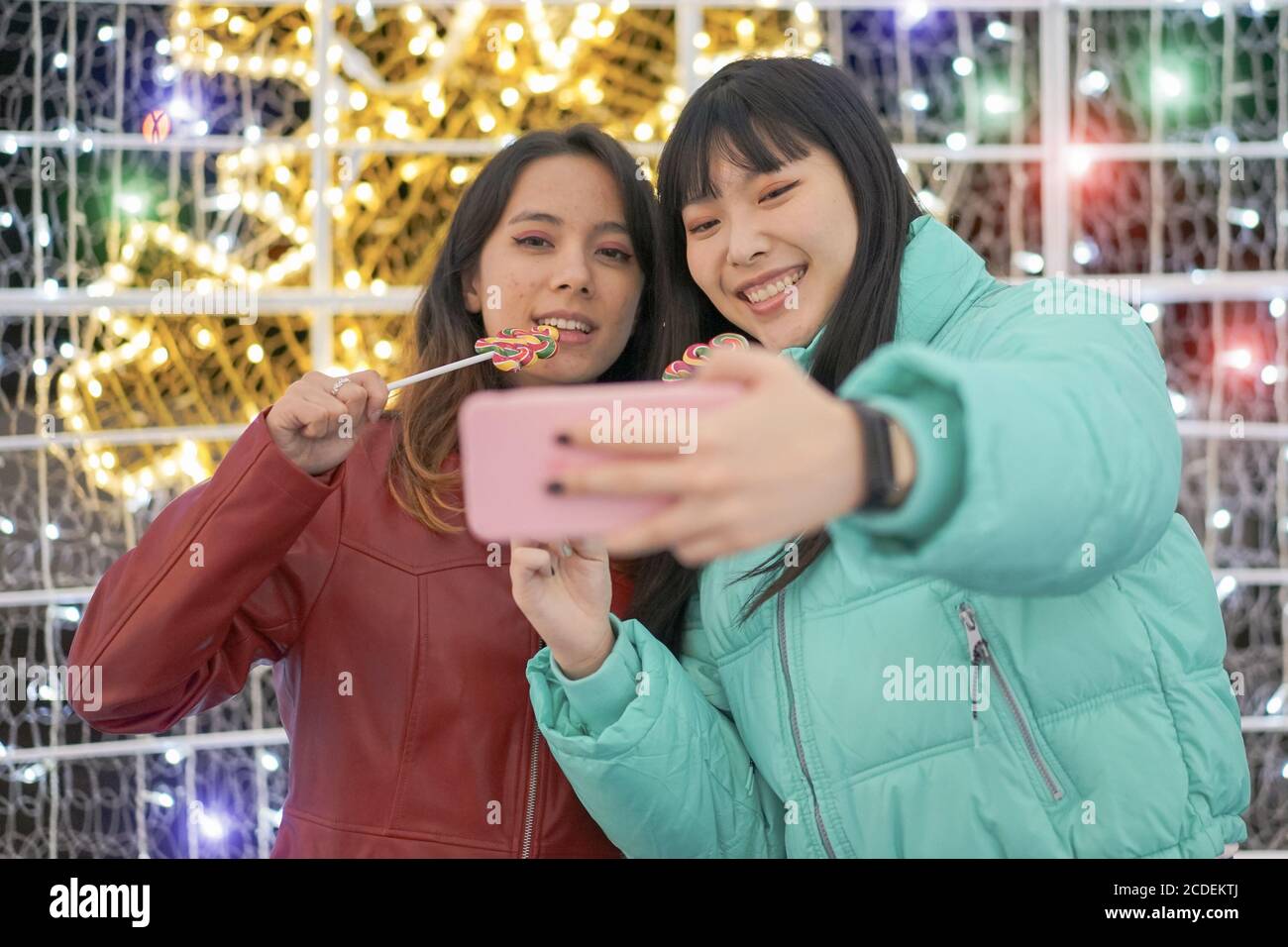 Selfie von jungen lächelnden Teenagern, die Spaß zusammen haben. Happy Young Friends mit süßen Bonbons in den Händen. Reise- und Freundschaftskonzept – Bild Stockfoto