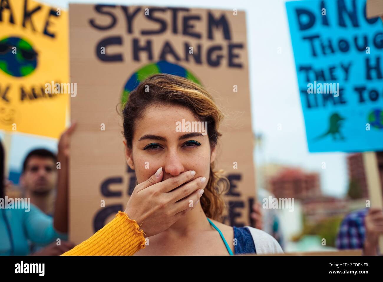 Menschen mit Schilder, die Gerechtigkeit und Klima fordern. Eine Gruppe von Demonstranten kämpft für den Klimawandel.Symbol der Frau, die von der Politik zum Schweigen gebracht wird Stockfoto