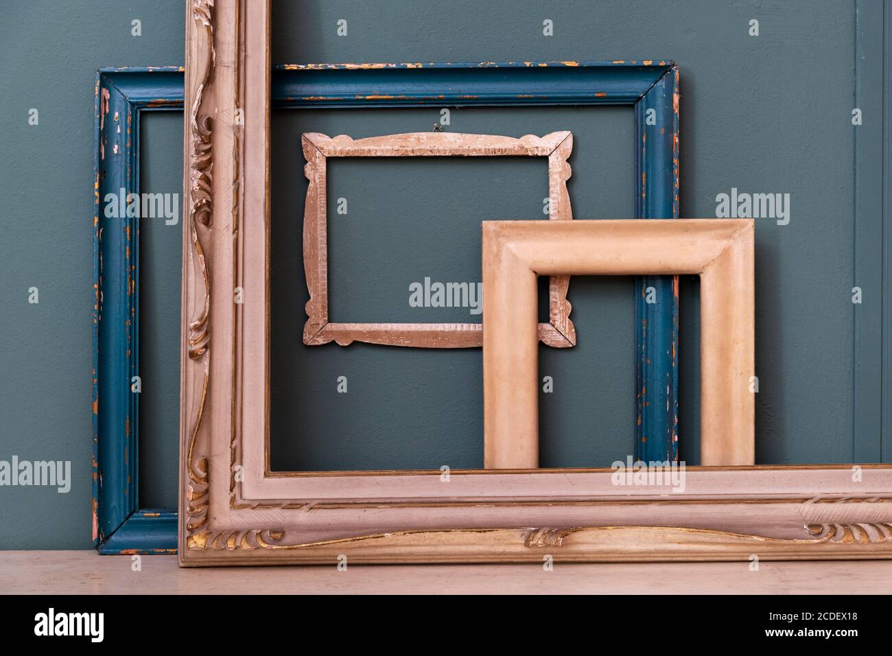 Sammlung von sortierten leeren rechteckigen Holz Vintage-Rahmen stehend aufrecht Gegen eine blaugrün gefärbte Wand in Nahaufnahme Stockfoto