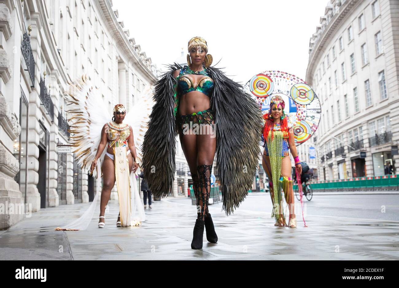 Ein Trio karibischer Soca-Tänzer, Donna Cupid-Tuesday, Andrea Wallace und Fiona Compton, unterhalten Passanten, während Samsung auf dem Piccadilly Circus einen Trailer zum ersten digitalen Notting Hill Carnival in London enthüllen wird. Stockfoto