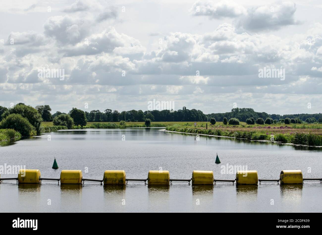 Gelbe Stahlseilmaschinen als Barriere im Fluss Vecht bei Zwolle, Niederlande, um Boote von der Staumauer fernzuhalten Stockfoto
