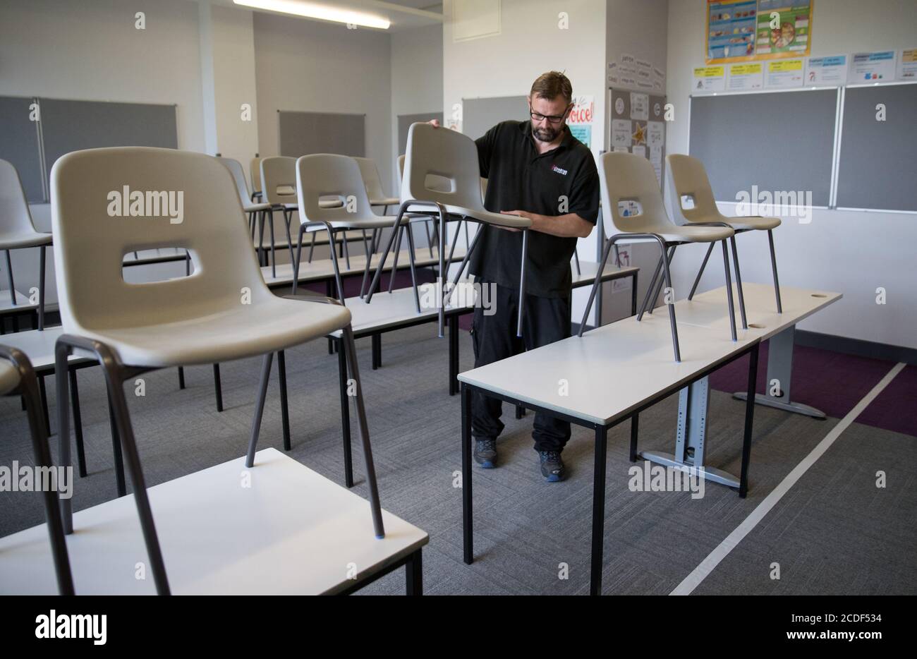 Die Lehrstühle werden in einem Klassenzimmer der Ark Charter Academy in Portsmouth abgesetzt, da die Vorbereitungen vor Beginn des neuen Semesters getroffen werden. Stockfoto