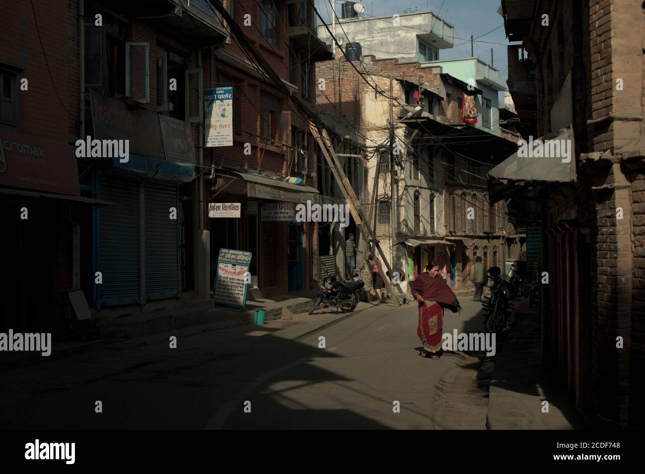 Eine Frau, die auf der Straße durch ein Wohngebiet in Bhaktapur, Provinz Bagmati Pradesh, Nepal, geht. Stockfoto