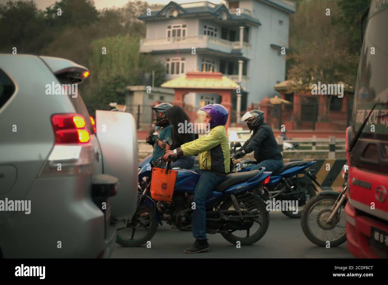 Motorradfahrer mitten im starken Verkehr während der Nachmittagshochzeit in Kathmandu, Nepal. Stockfoto