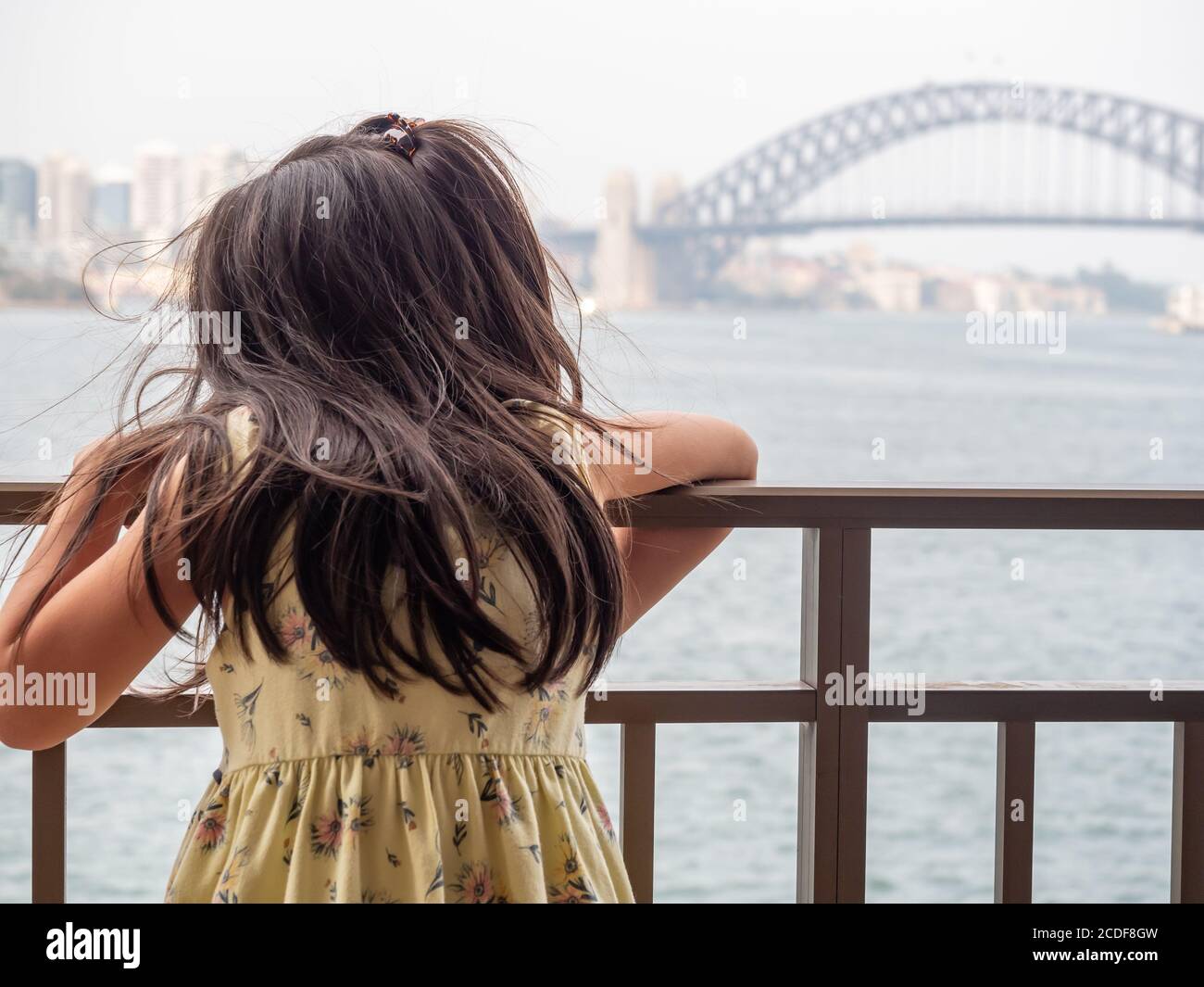 Vorschulkinder mit Blick auf den Hafen von Sydney und einem Metallgeländer und Harbour Bridge Hintergrund Weichzeichnen Stockfoto