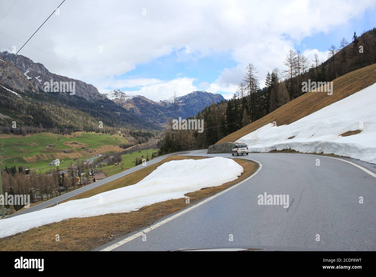 Straße durch die Berge mit schmelzendem Schnee im Frühling Stockfoto