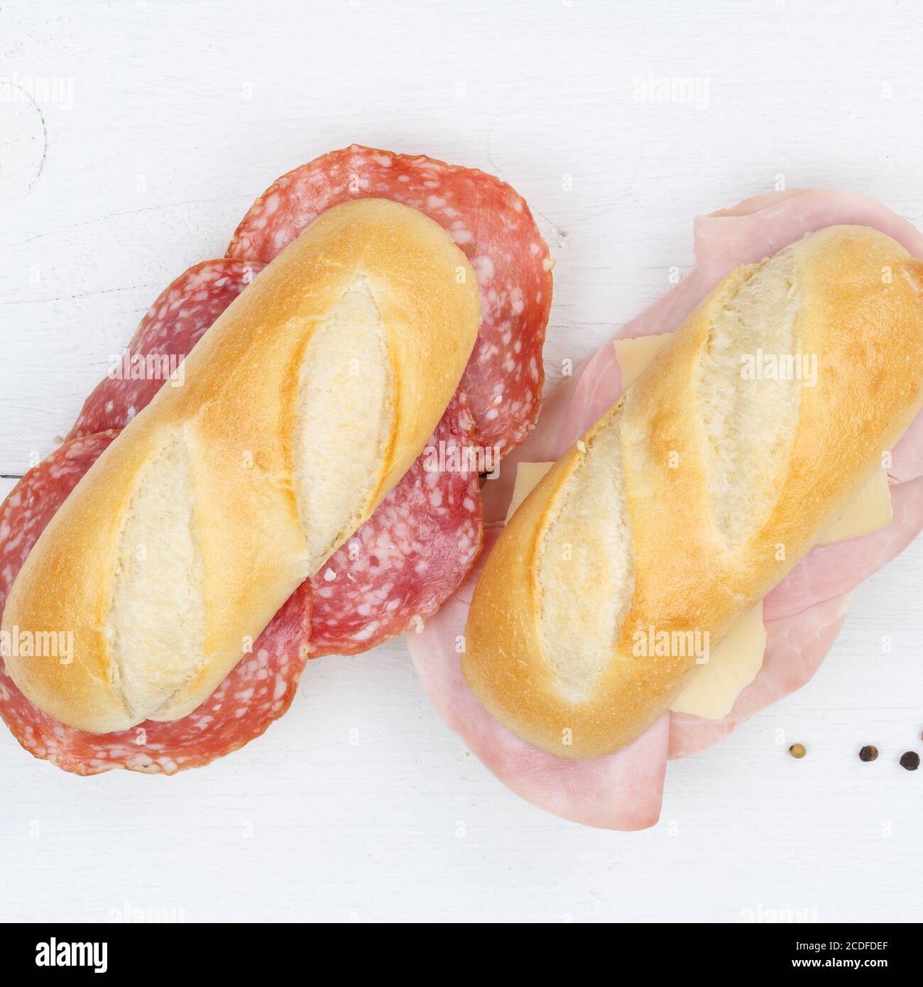 Sub Sandwiches Baguettes mit Salami Schinken und Käse Quadrat aus Oben auf Holzbrett Holz Stockfoto
