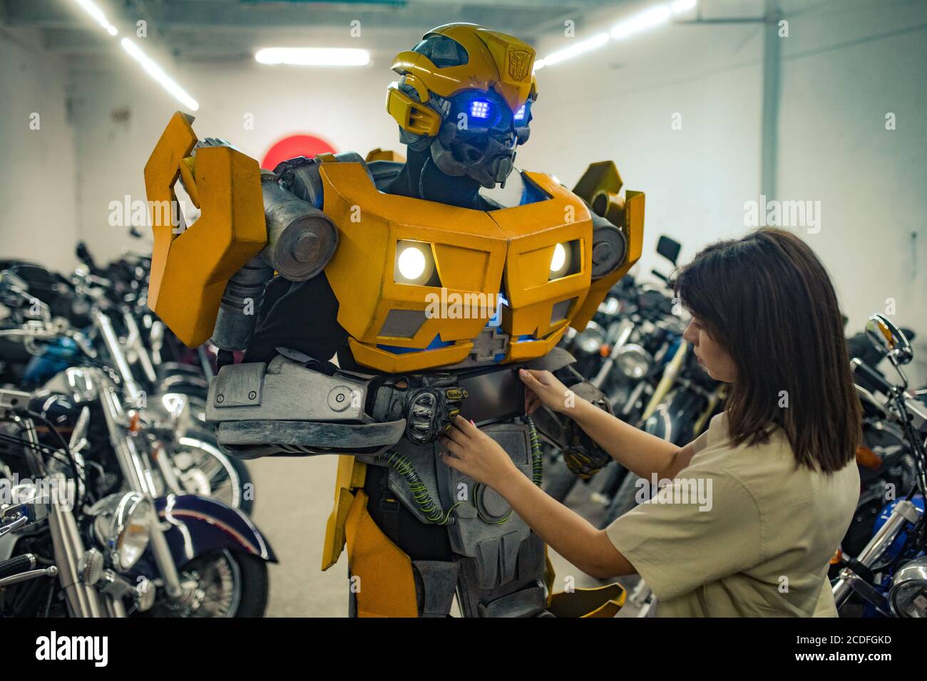 Mädchen steht in der Nähe Roboter Transformator und repariert ihn in der Garage. Stockfoto