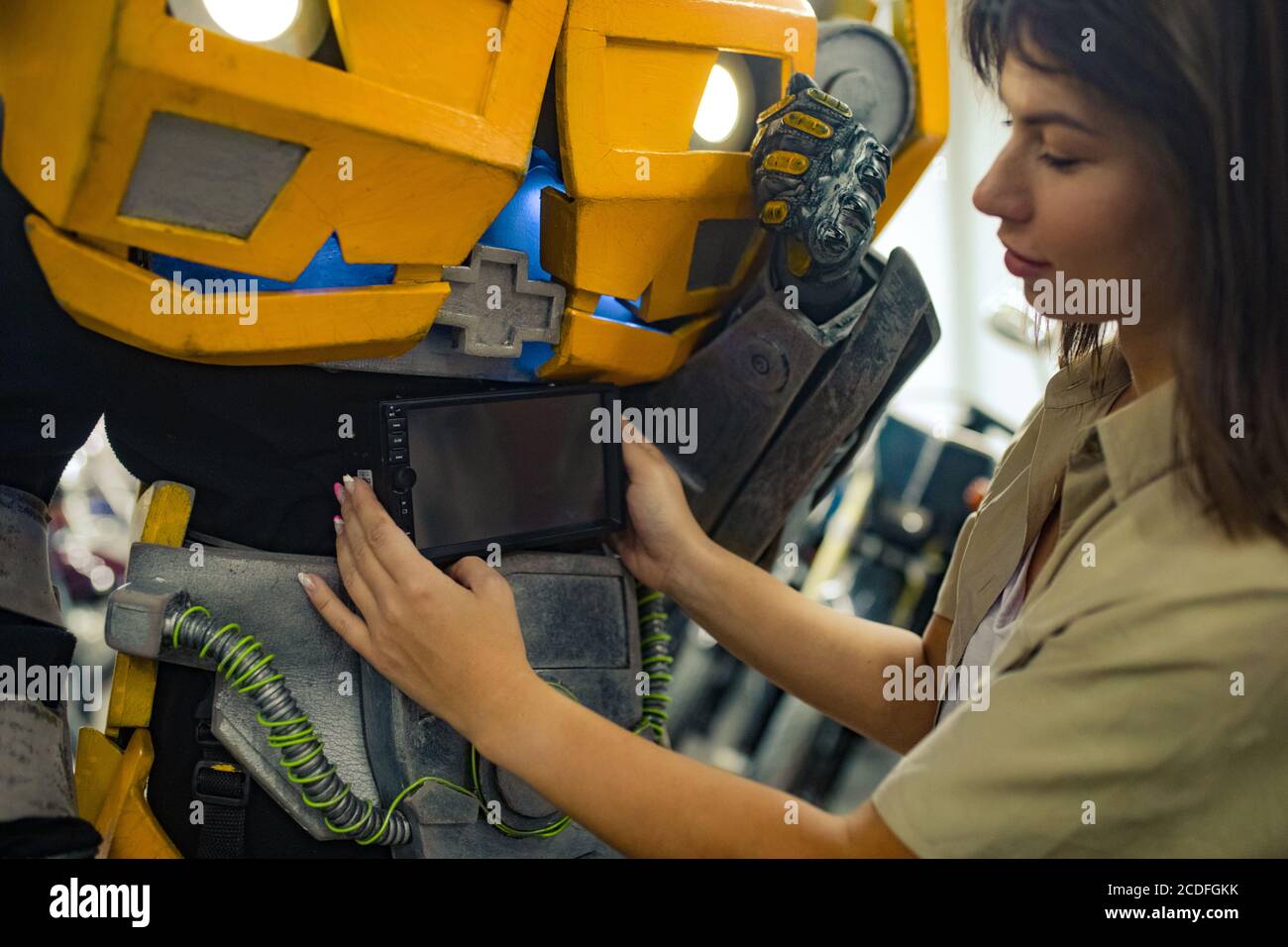 Mädchen steht in der Nähe Roboter Transformator und repariert ihn in der Garage. Stockfoto