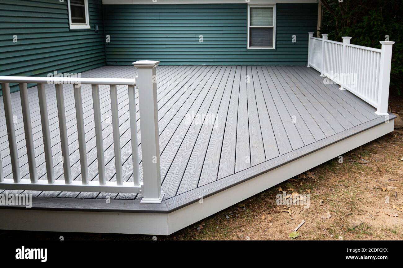 Neues Verbunddeck auf der Rückseite eines Hauses mit grünem Vinyl-Abstellgleis.mit Whie Geländer. Stockfoto