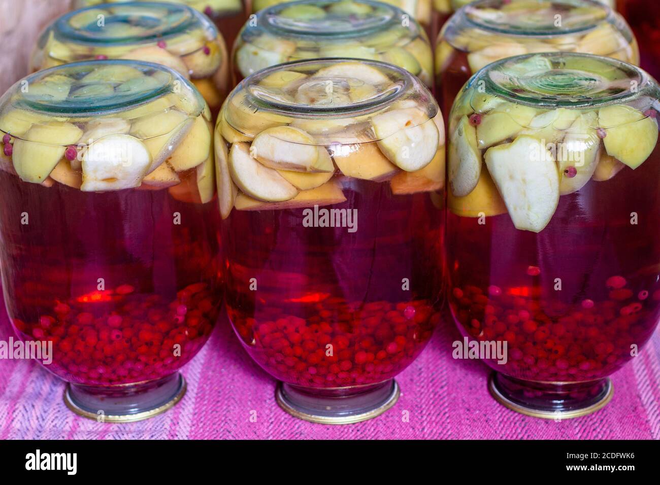 Hausgemachtes Fruchtkompott aus der Dose für den Winter. Kompott aus Äpfeln und roter Johannisbeere. Invertierte Gläser Stockfoto